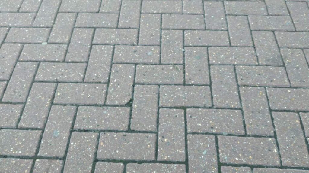 Close-up view of a herringbone-style block paving pattern on a residential driveway
